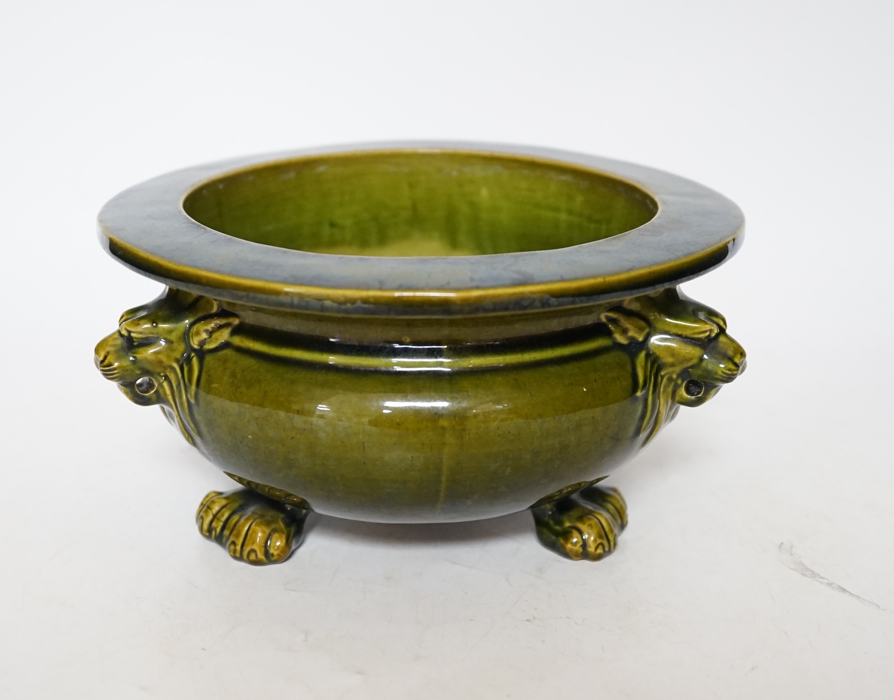 A green glazed Art pottery planter raised on three paw feet, diameter 20.5cm. Condition - good